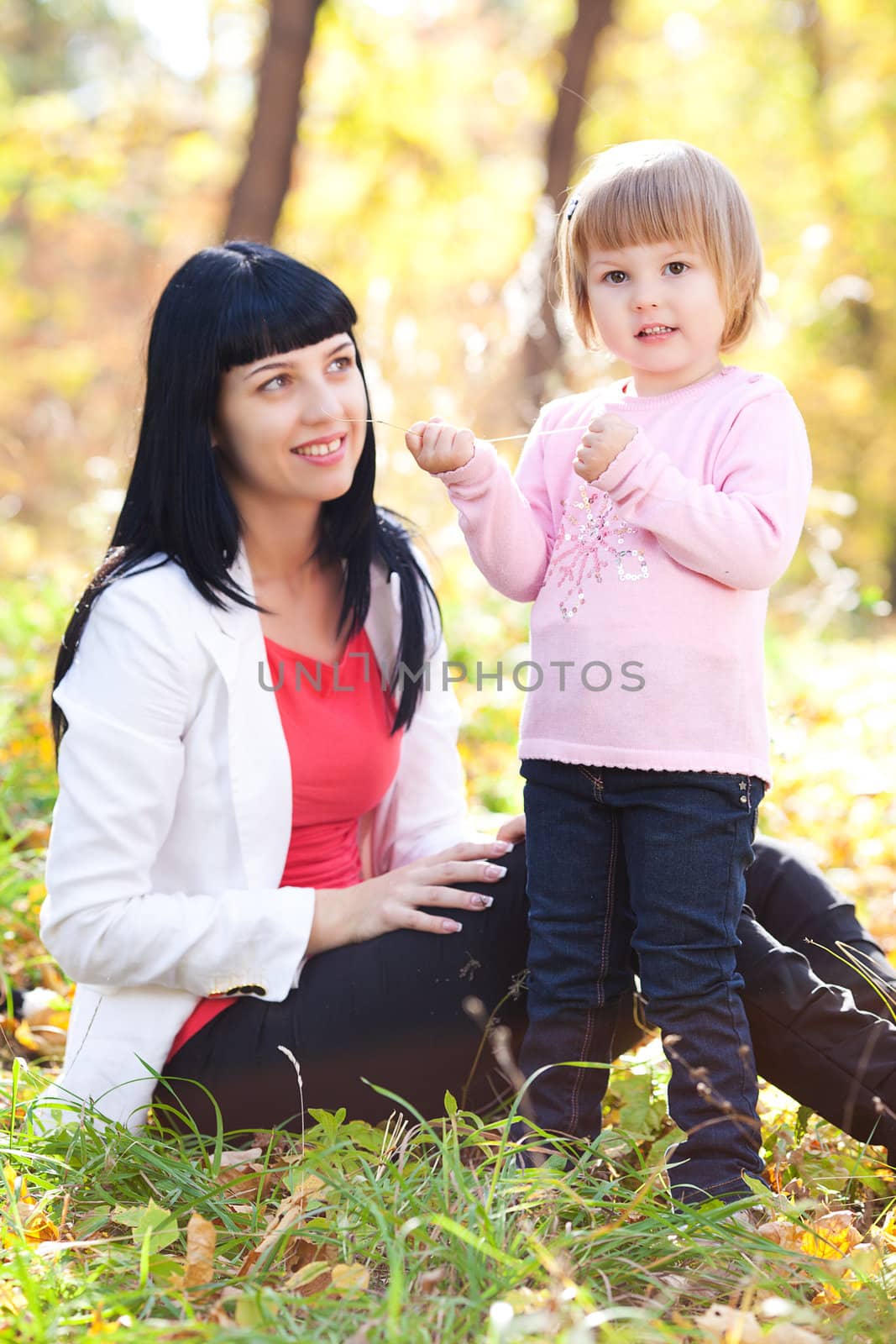 beautiful young mother and her daughter on the autumv forest