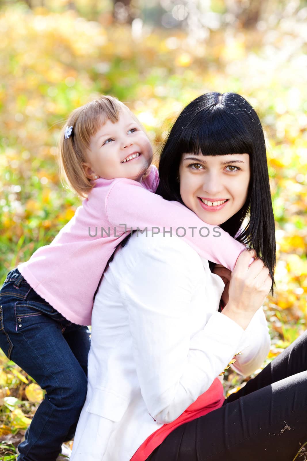 beautiful young mother and her daughter on the autumv forest