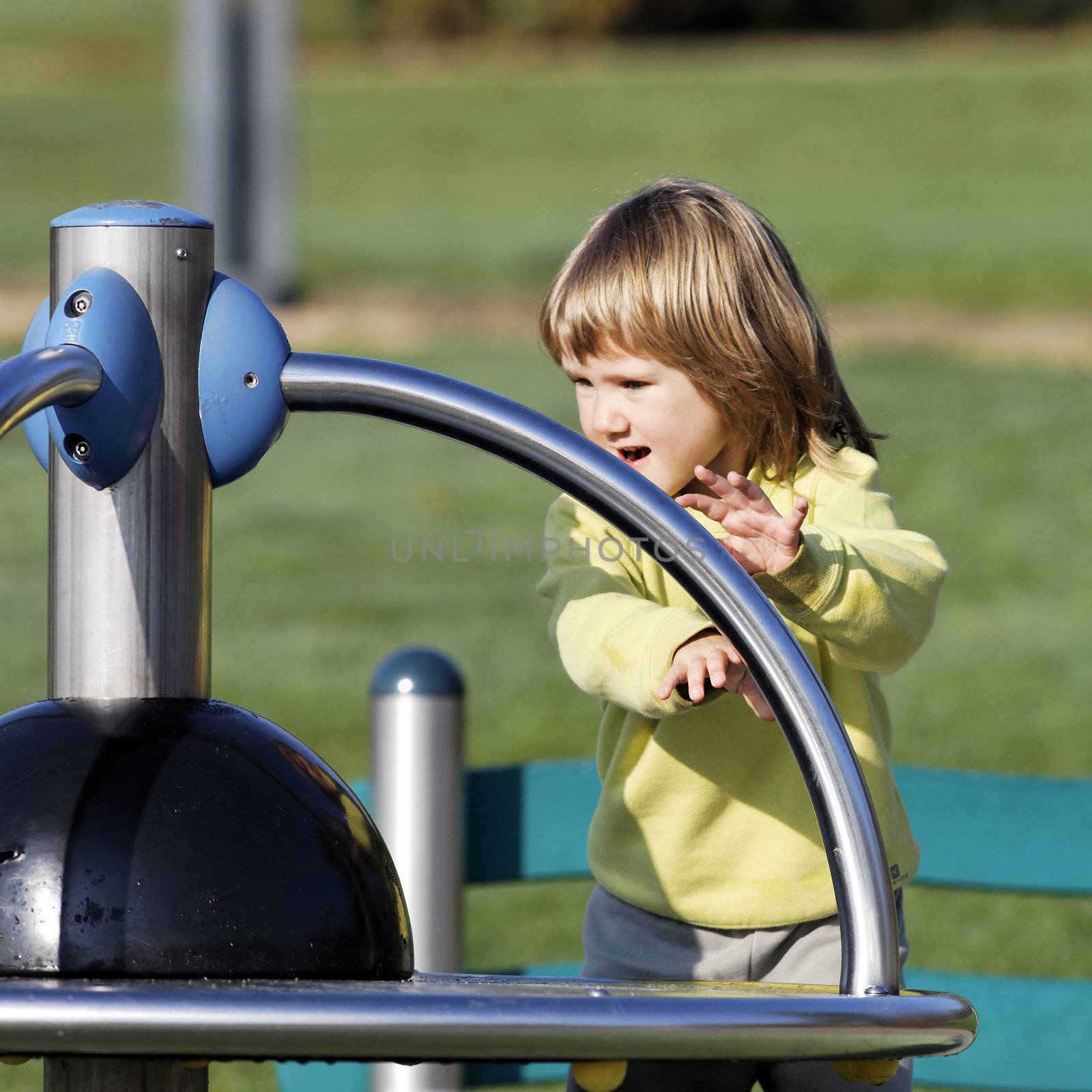 child playing on playground in a park in autumn