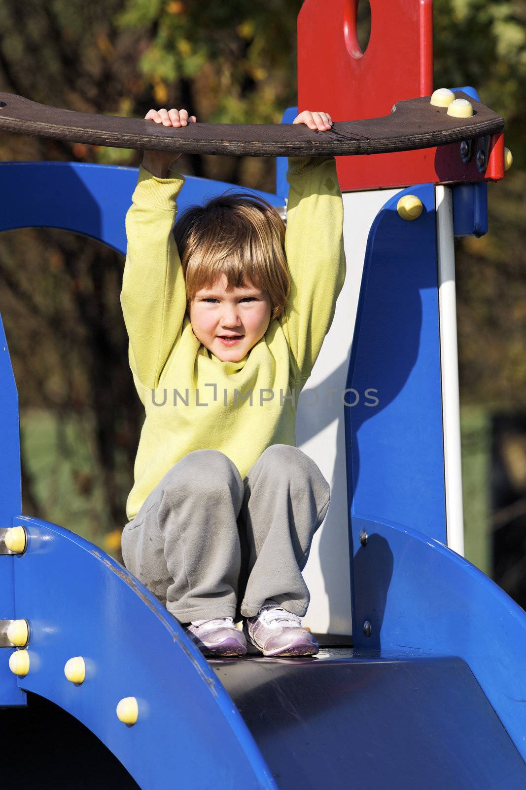 Small child playing on colorful playground 