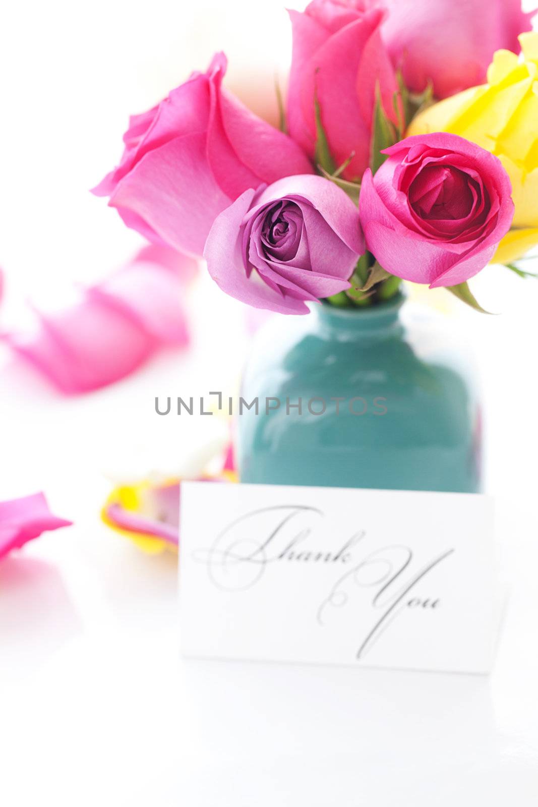 bouquet of colorful roses in vase,petals and card with the words thank you