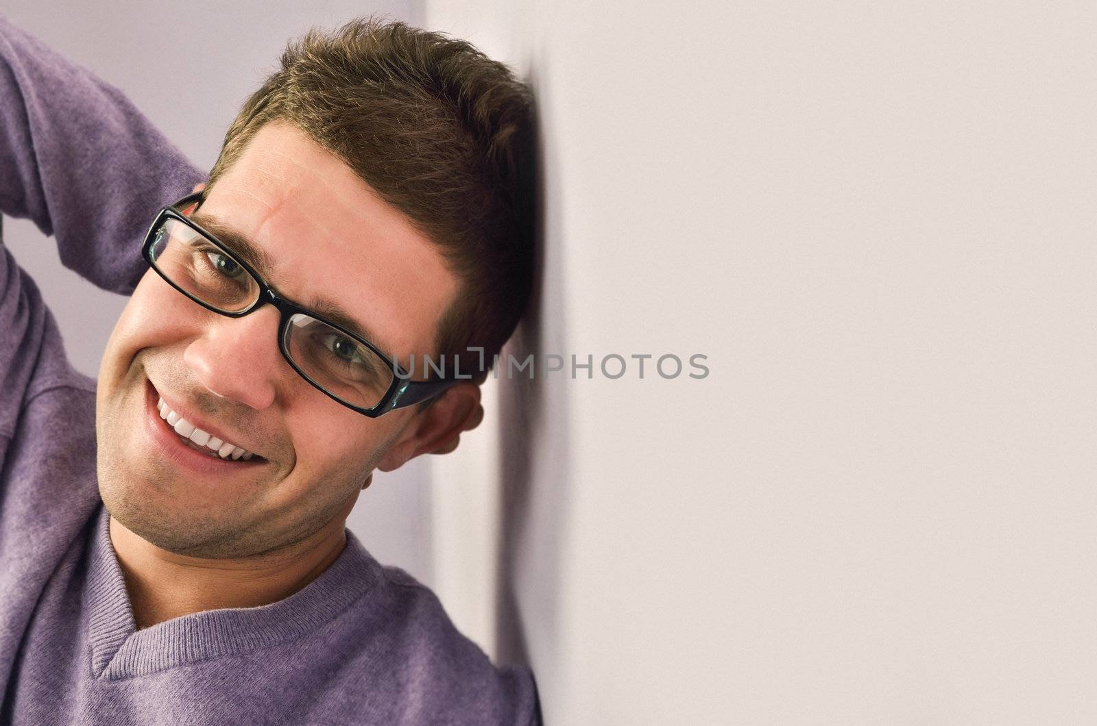 Young man looking at camera, a look of satisfaction on his face.