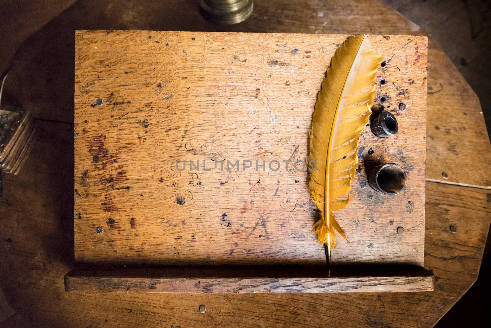 High angle shot of old quill and ink well on wooden writing desk