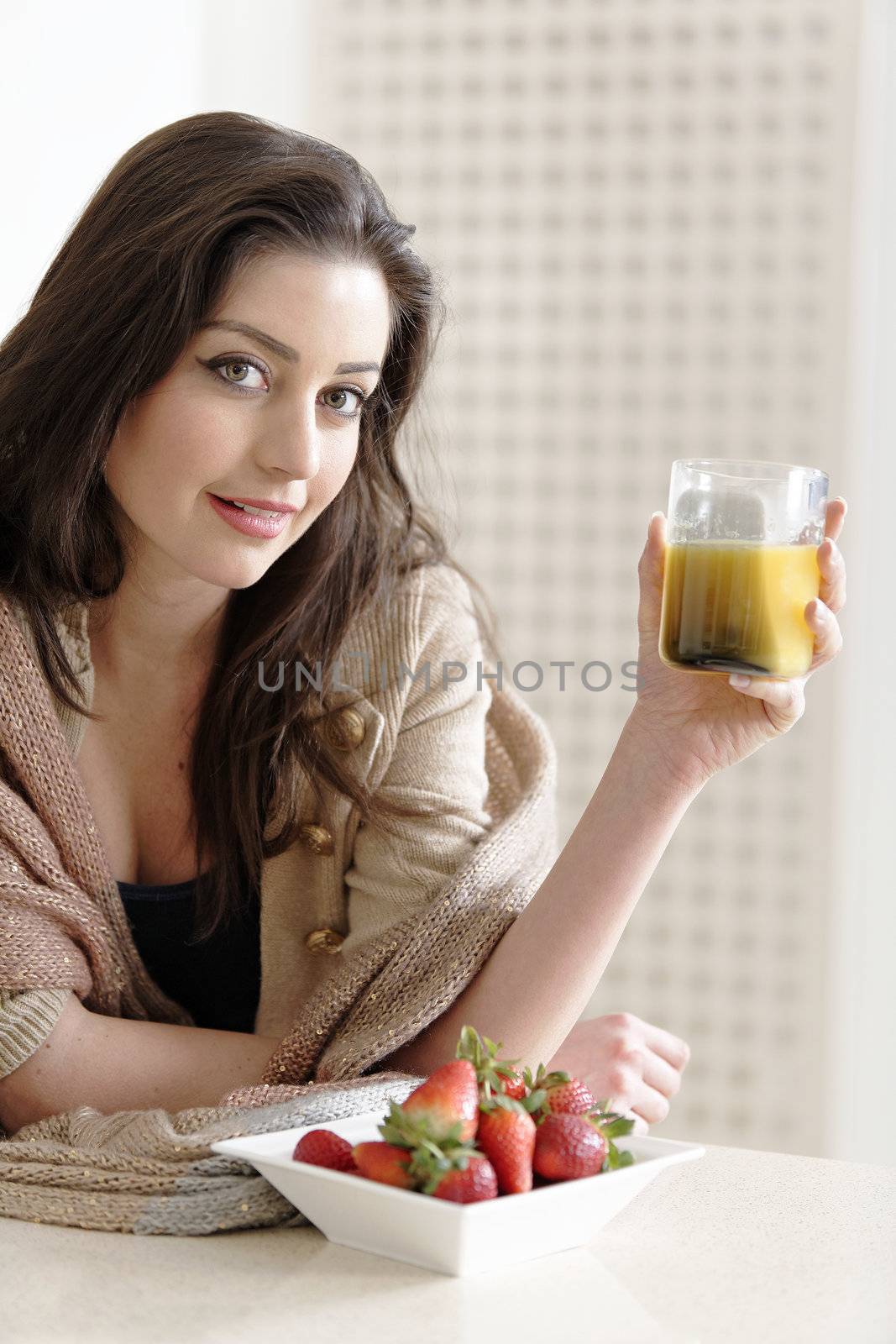 Attractive young woman enjoying a fresh fruit breakfast at home.