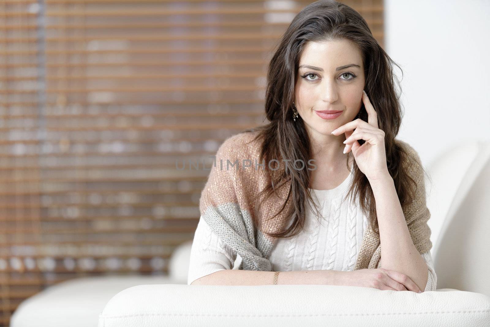 Woman relaxing on her sofa by studiofi