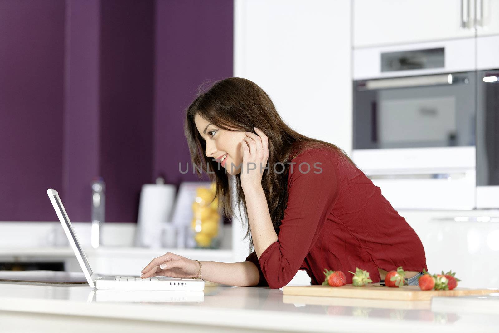 Woman in kitchen reading recipe  by studiofi