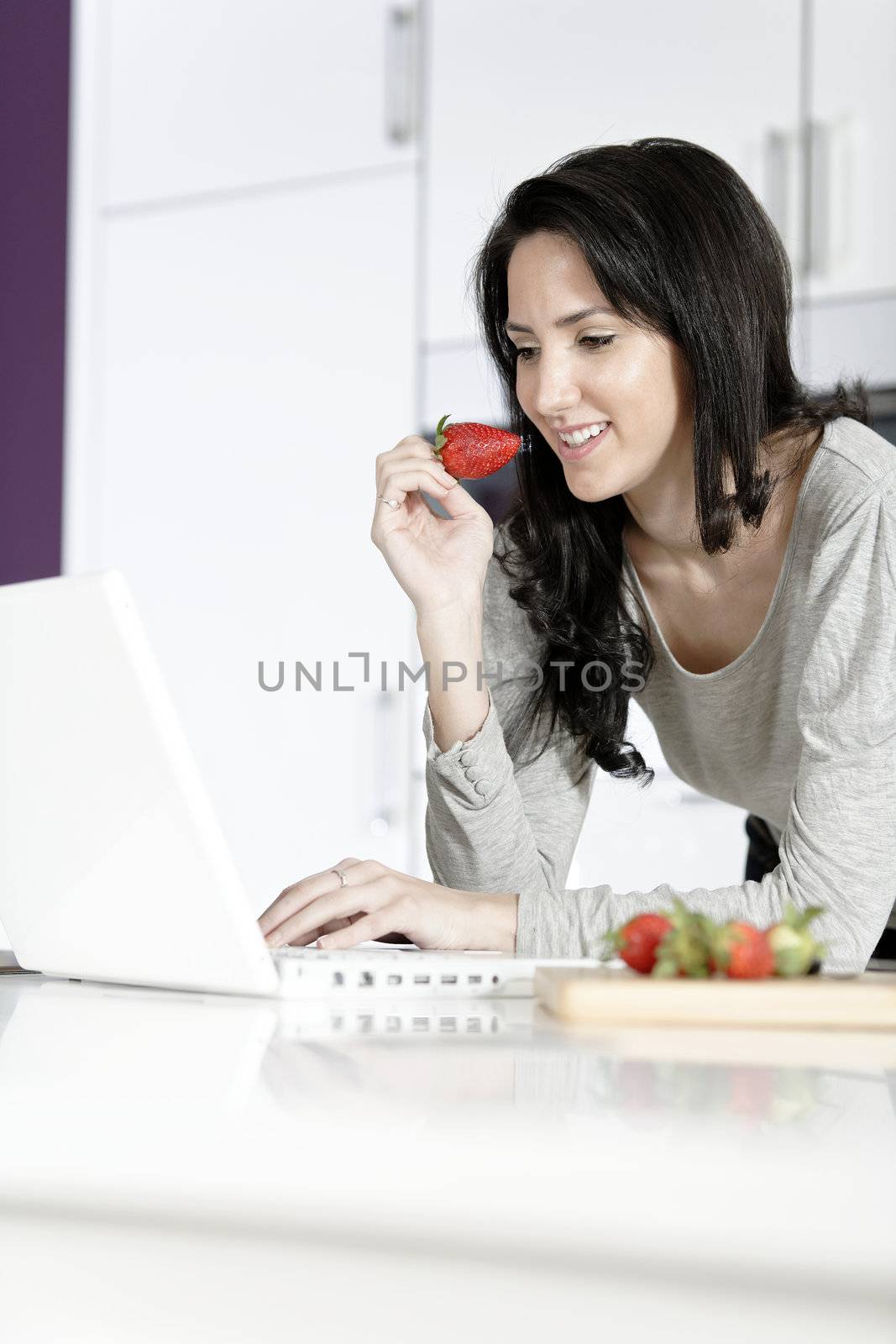 Woman in kitchen reading recipe  by studiofi