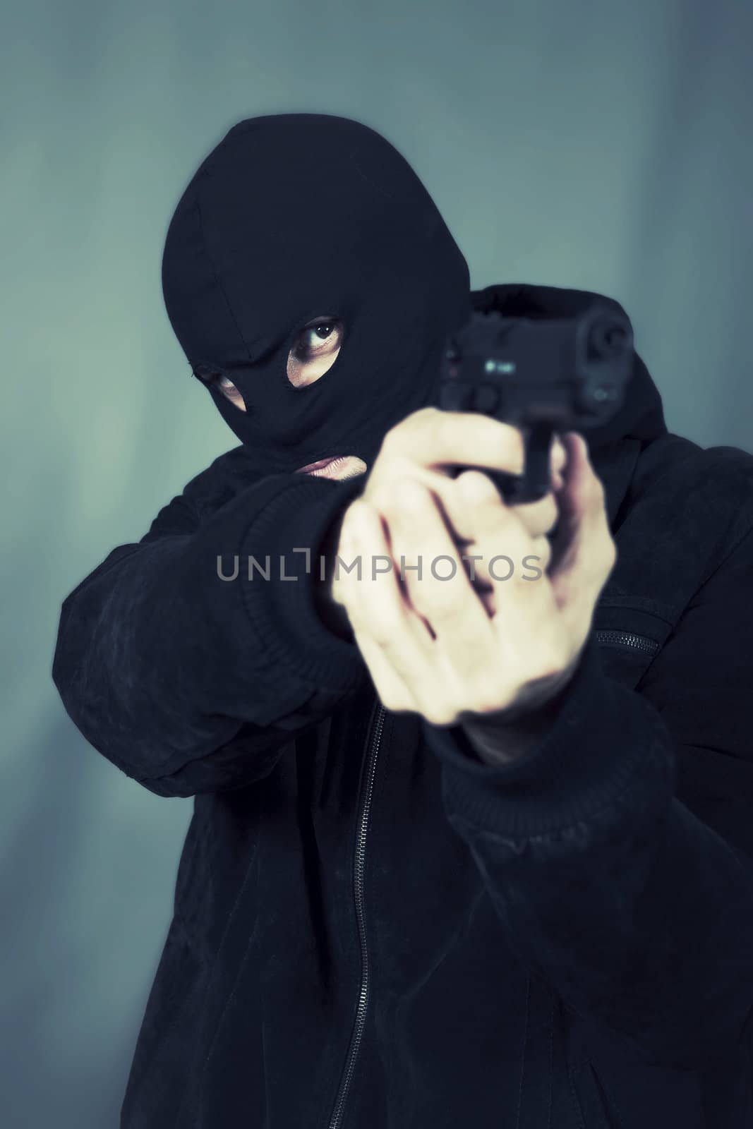 black dressed man with gun in studio