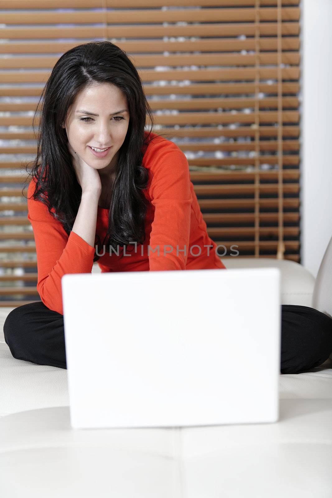 Attractive woman using her laptop in her living room.