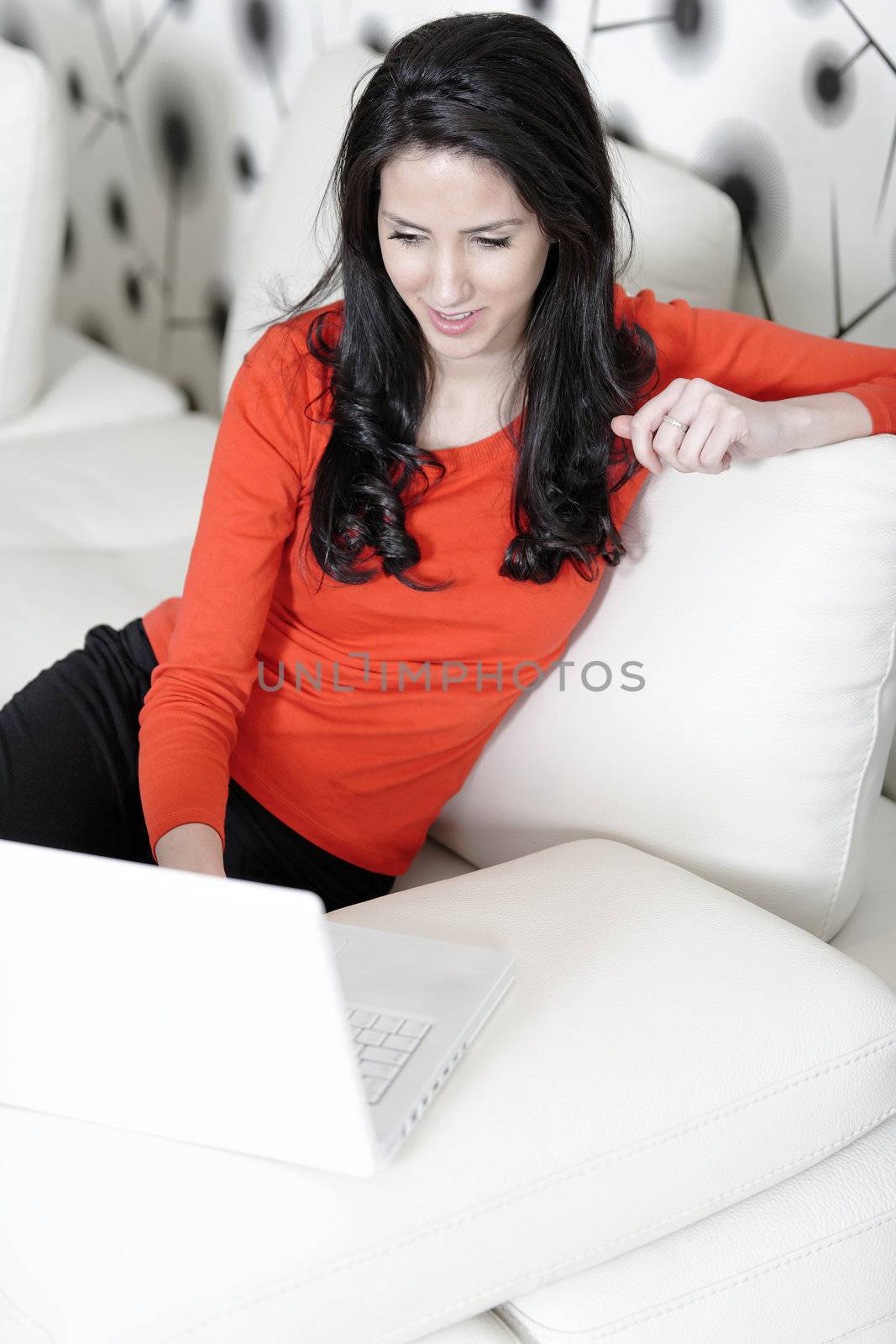 Attractive woman using her laptop in her living room.