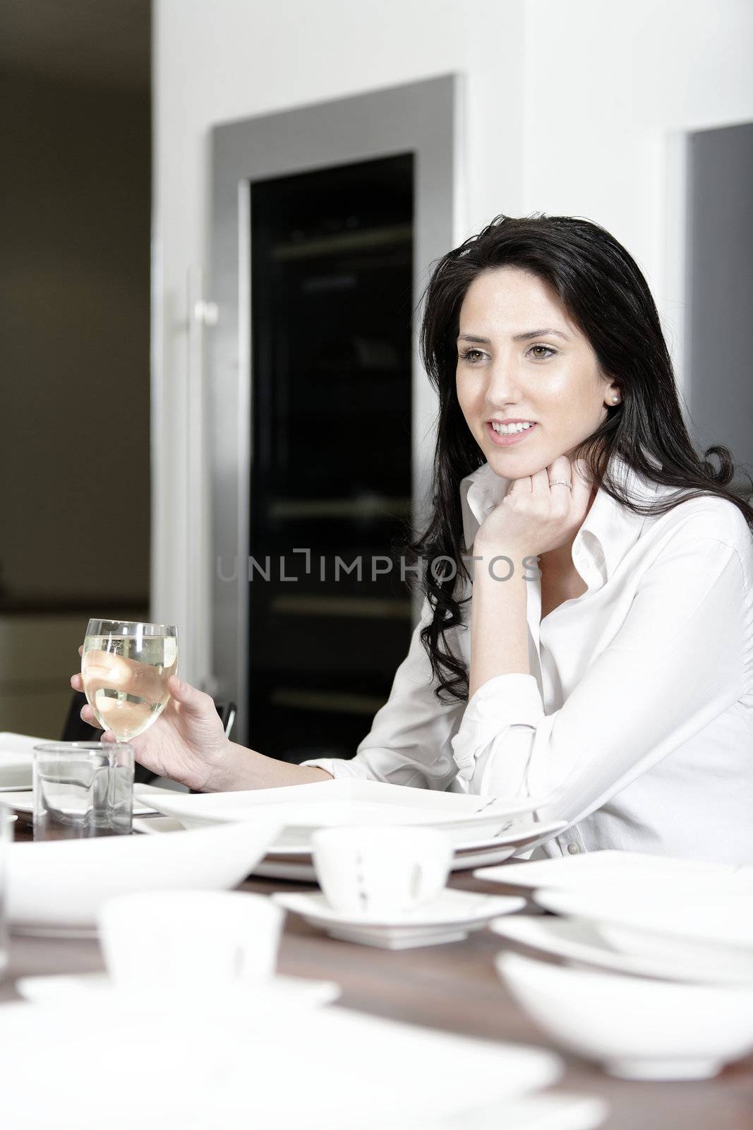 Attractive elegant woman enjoying a meal at the dinner table.