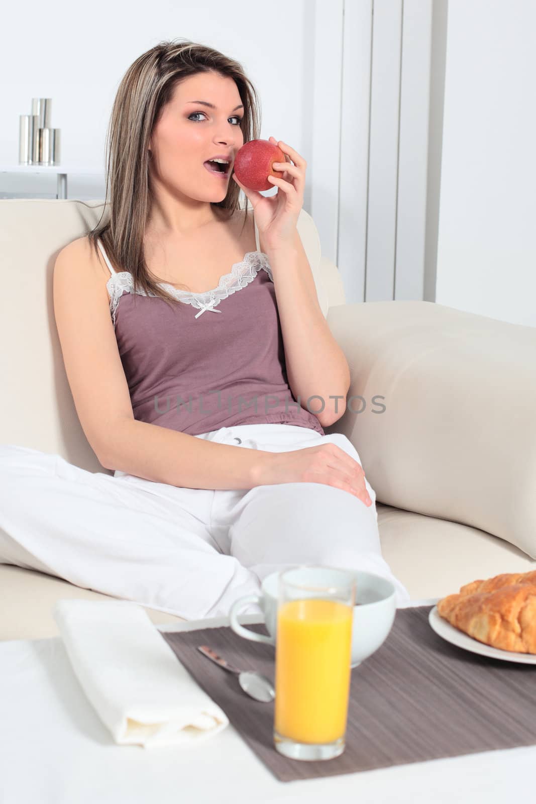 woman on sofa with breakfast on table