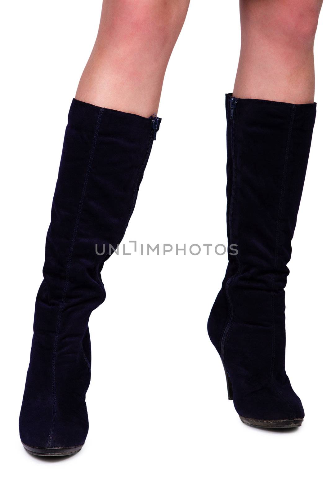 Slender female legs in black suede boots. Isolated over white background.