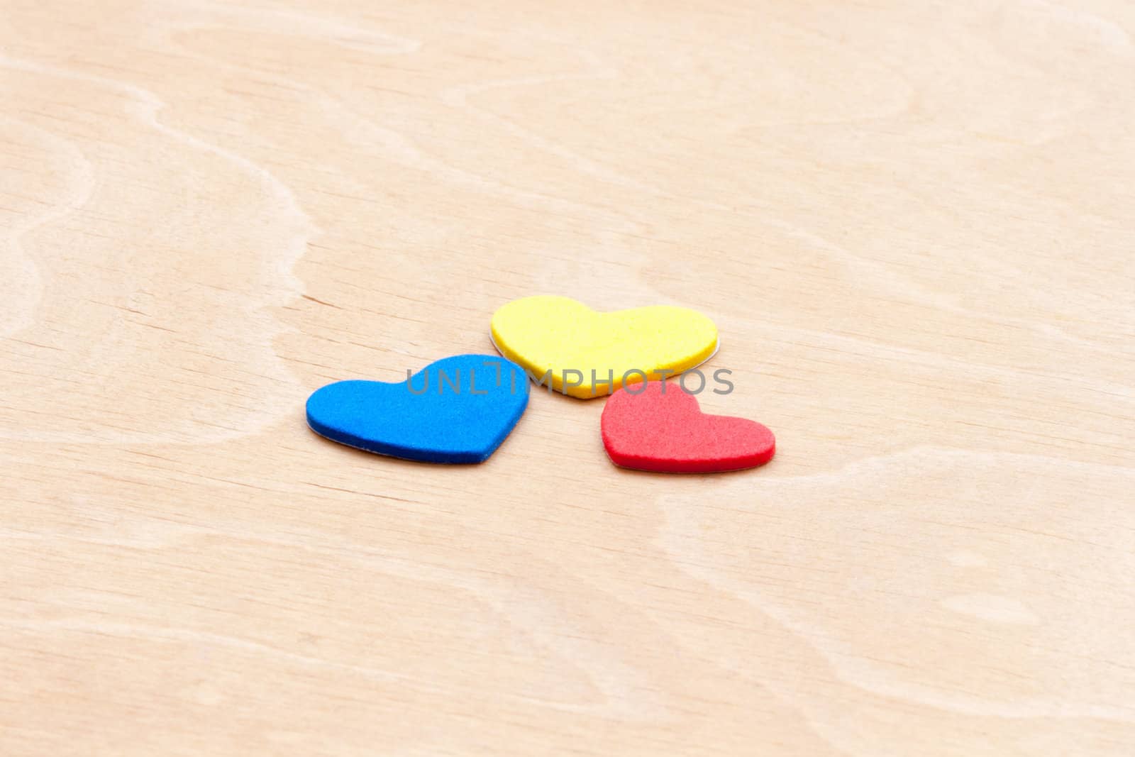 multicolored hearts on a white wooden background by sfinks