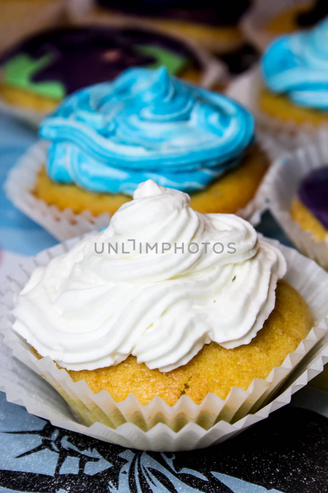 Some colored cupcakes with cream
