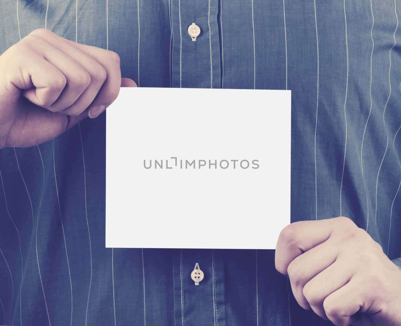 Closeup of businessman's hand holding up card