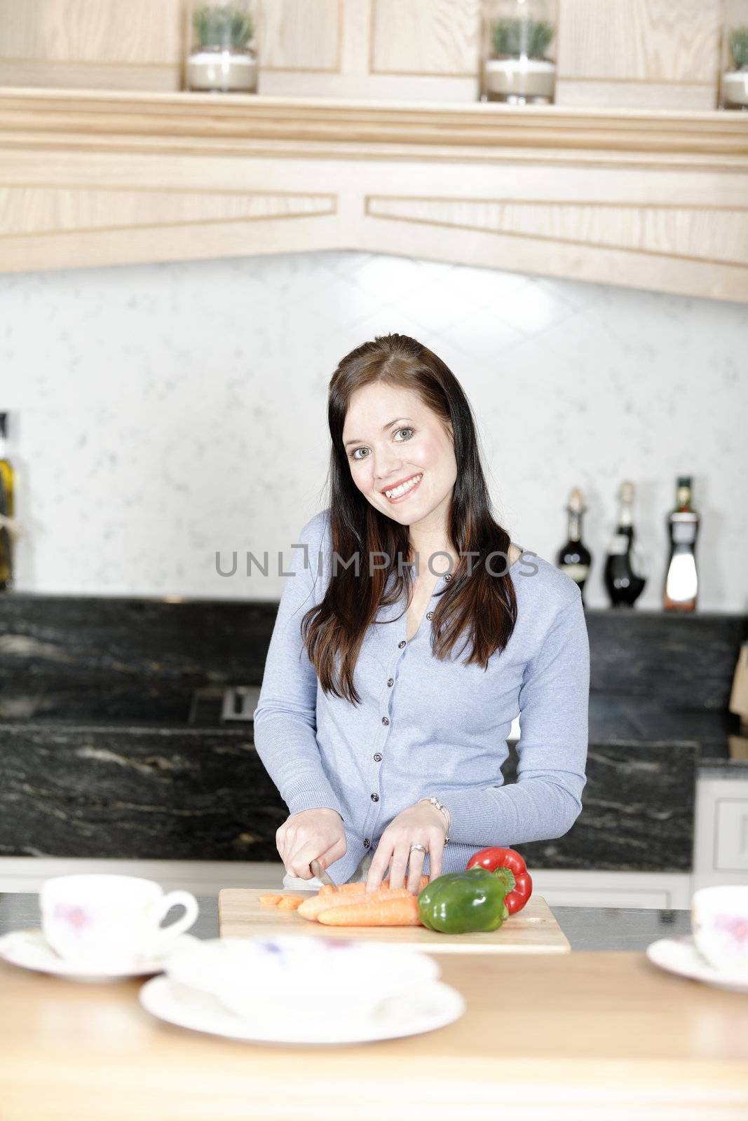 Beautiful young woman preparing the ingredients for a meal in her kitchen.