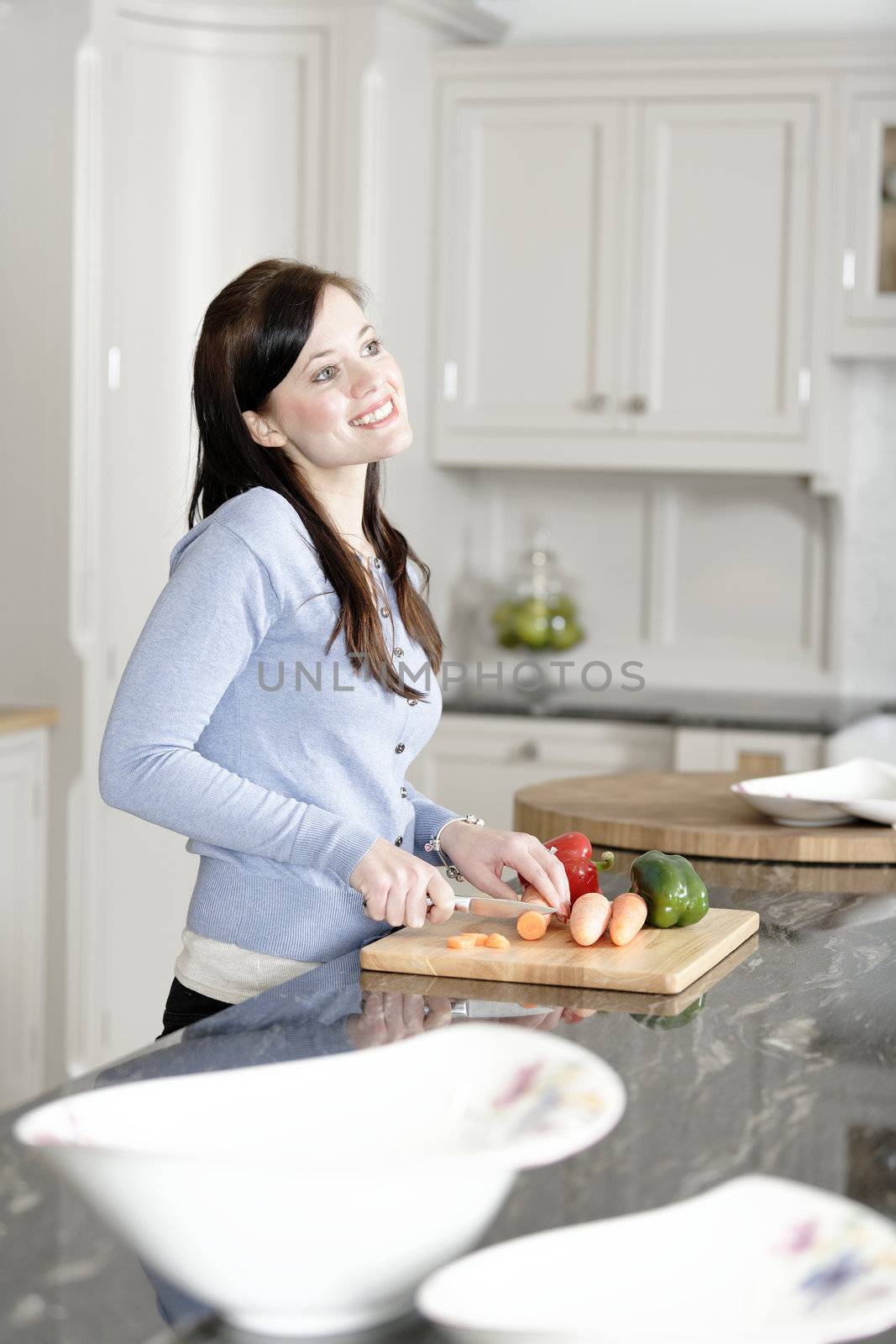 Beautiful young woman preparing the ingredients for a meal in her kitchen.