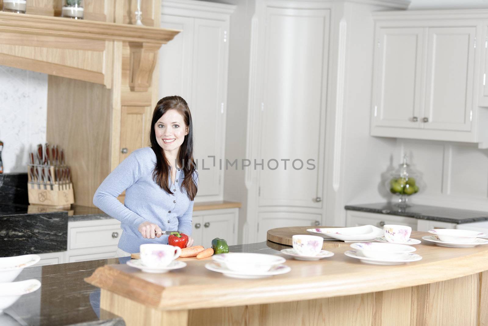 Beautiful young woman preparing the ingredients for a meal in her kitchen.