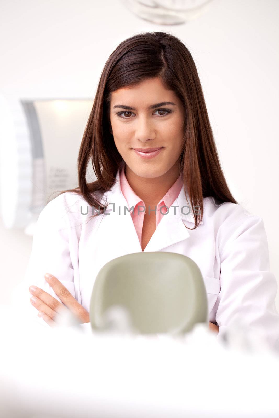 A young woman dentist smiling looking at the camera