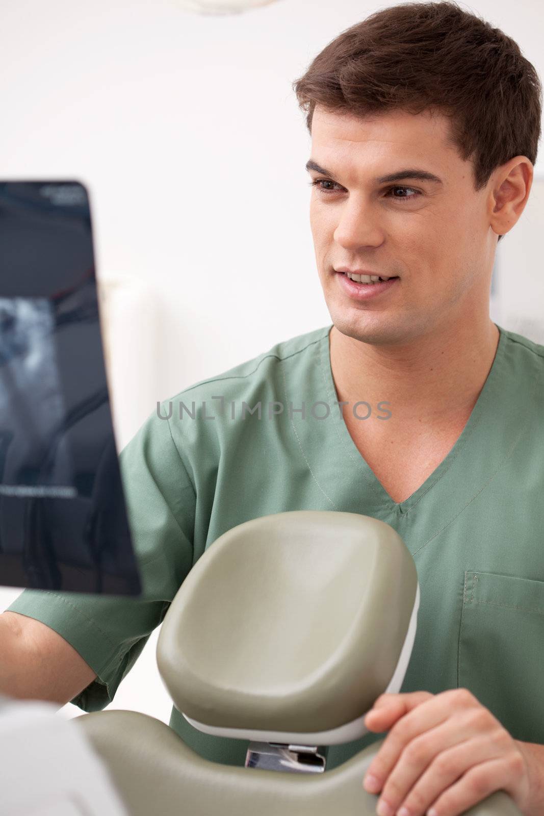 Young male dentist looking at an x-ray