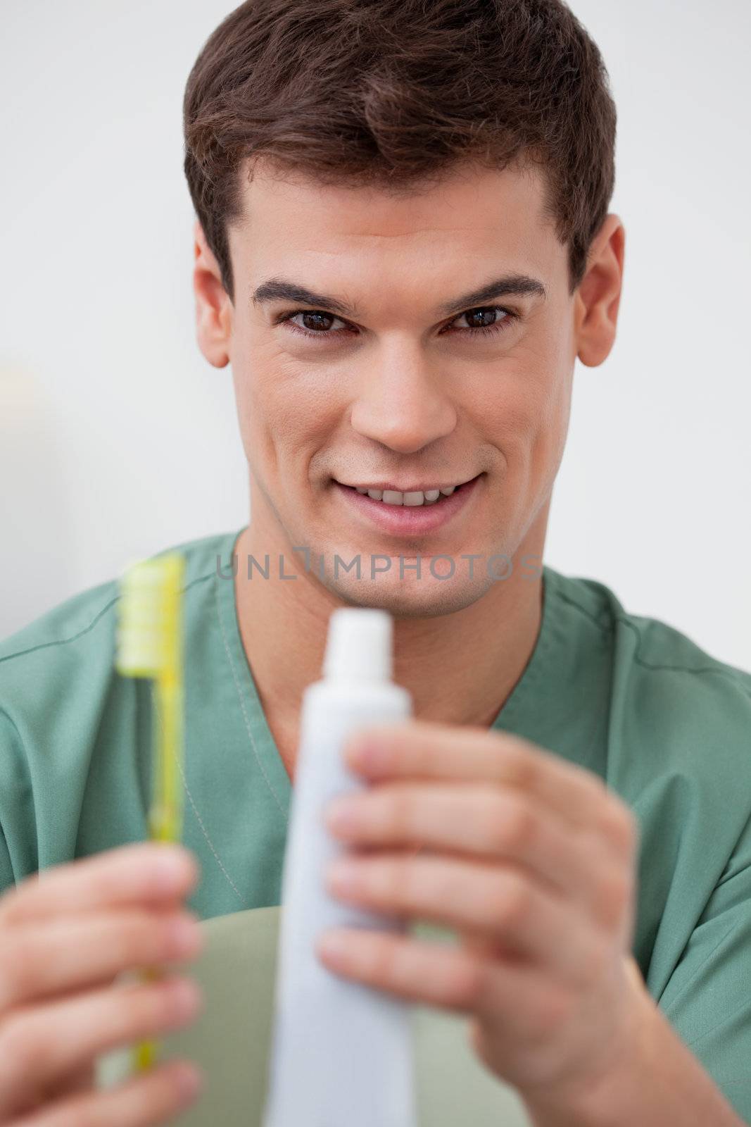 Portrait of dentist holding toothpaste and toothbrush