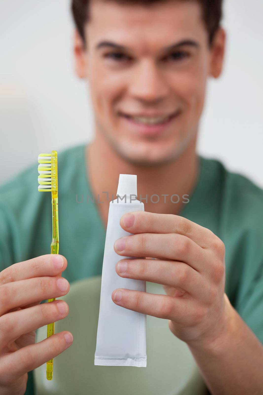 Dentist holding toothpaste and toothbrush by leaf
