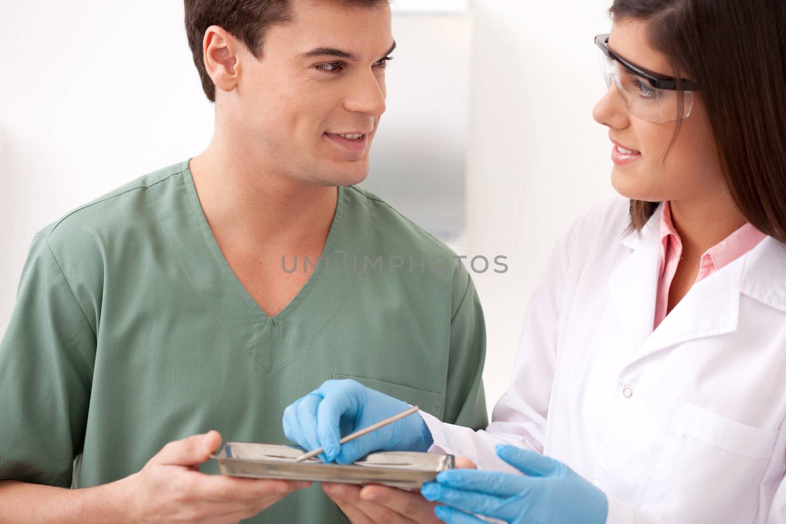 A male and female dentistry tream looking at eachother with a smile