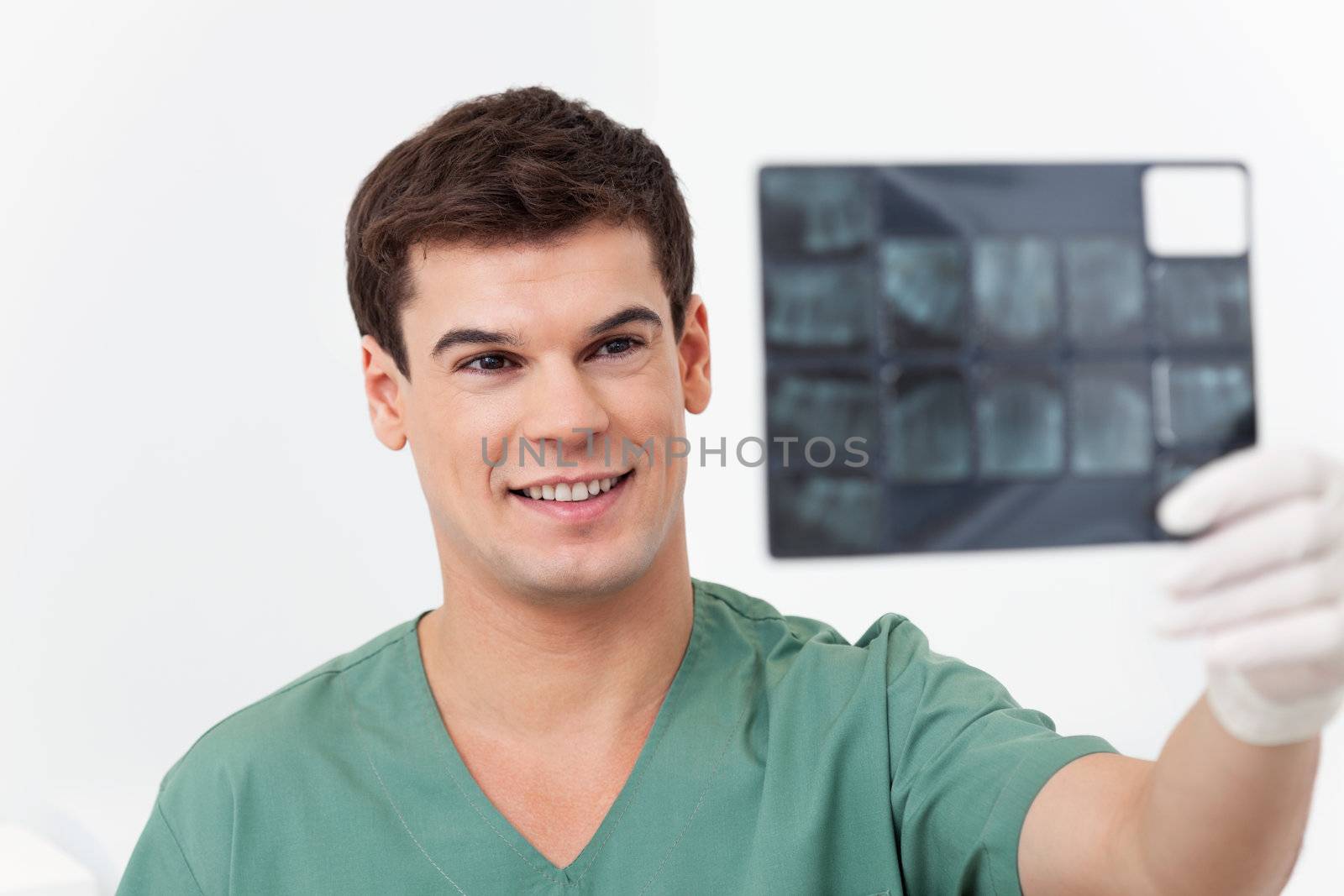 Young smiling doctor analyzing a dental X-Ray detail