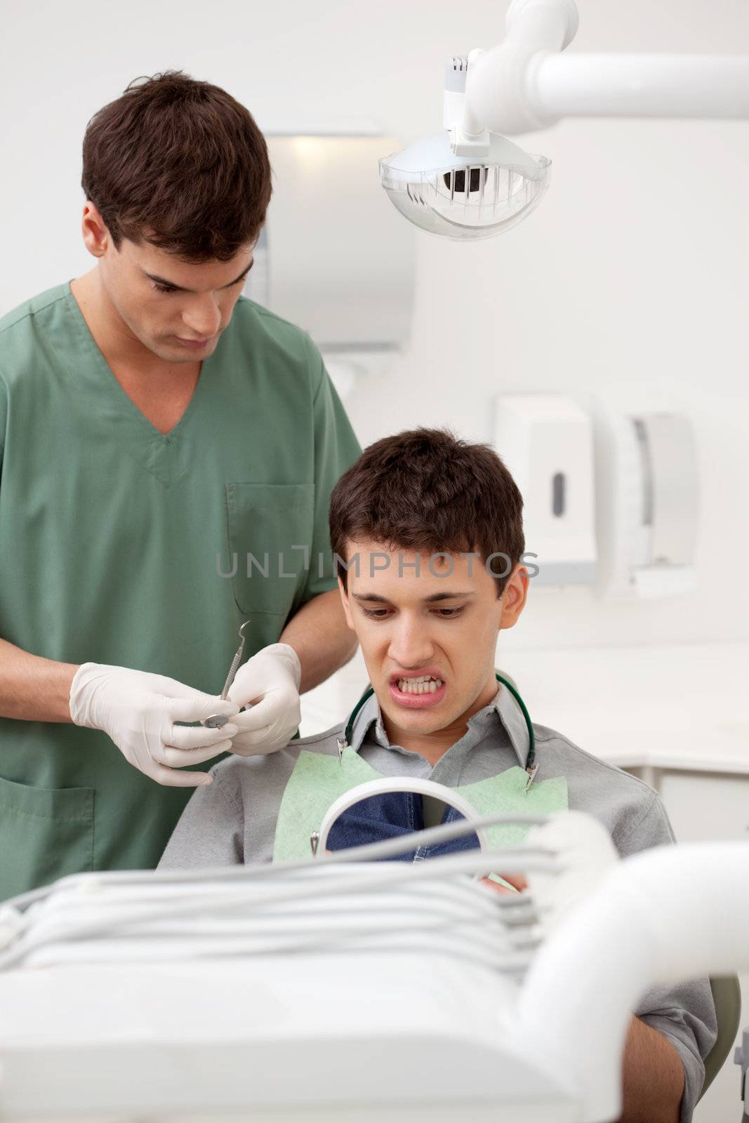 Dentist with Patient Looking at Teeth by leaf