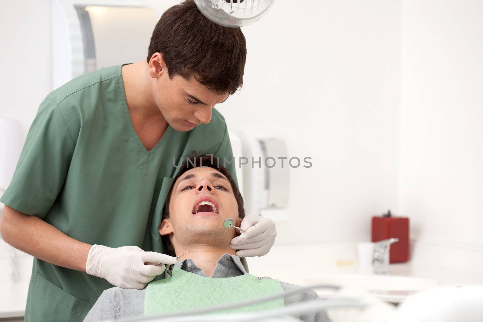 Young man at the dentist having his teeth inspected