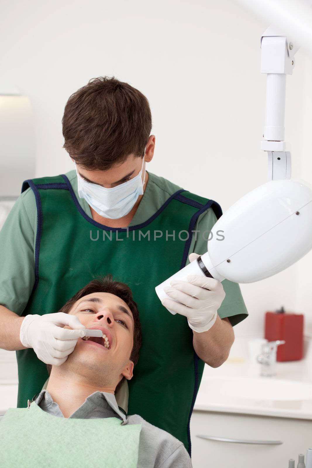 Young male dentist preparing an x-ray on a patient