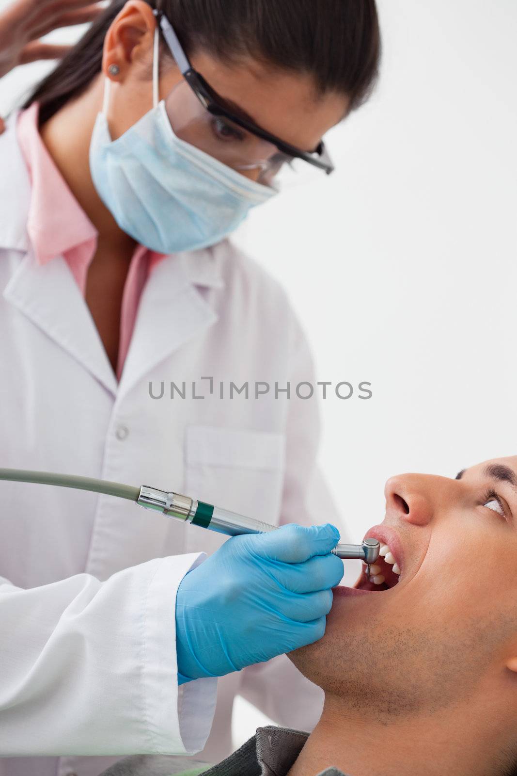 Dentist Using Drill on Patients Teeth by leaf