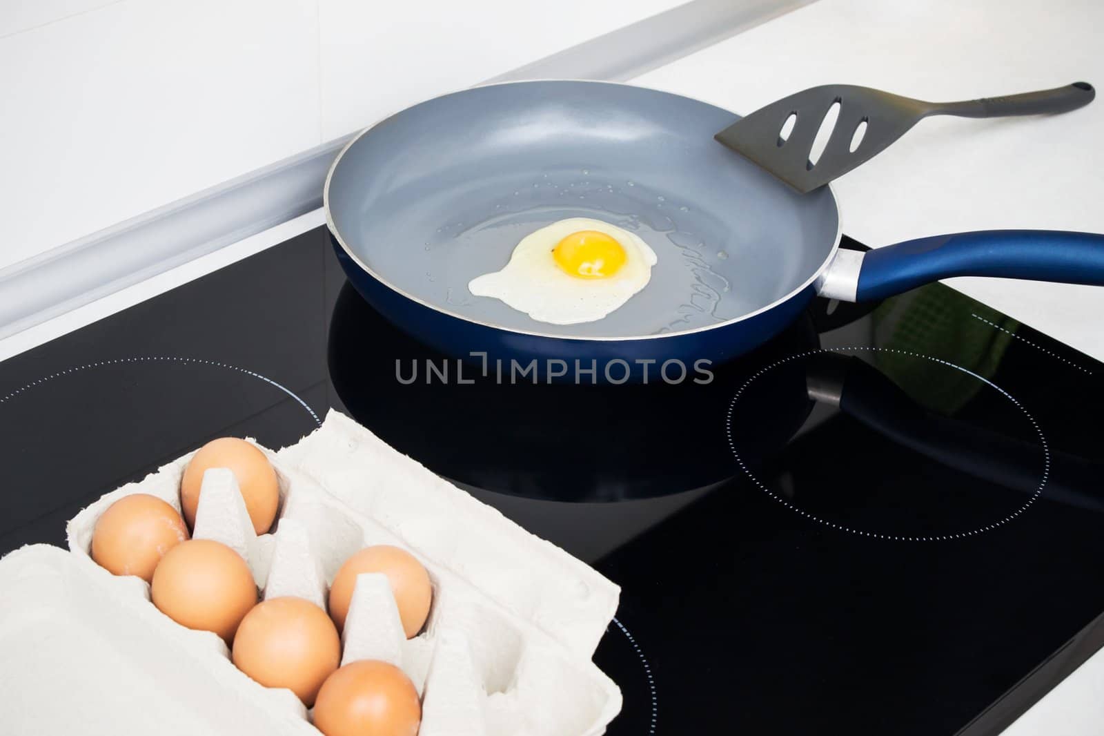 Fried egg in a frying pan on induction stove