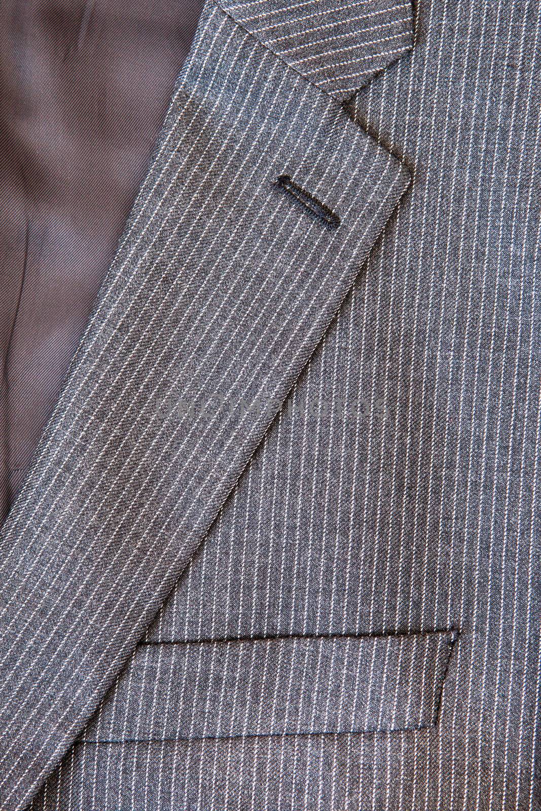 Close up of the collar and breast pocket of a pin stripe suit