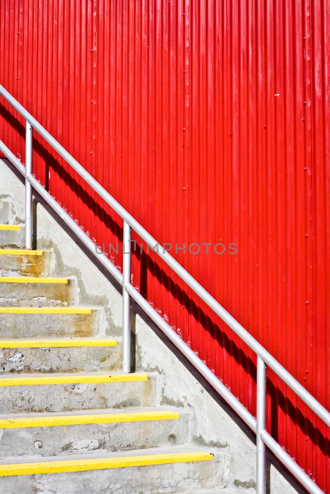 Concrete staircase in fron tof a bright red wall