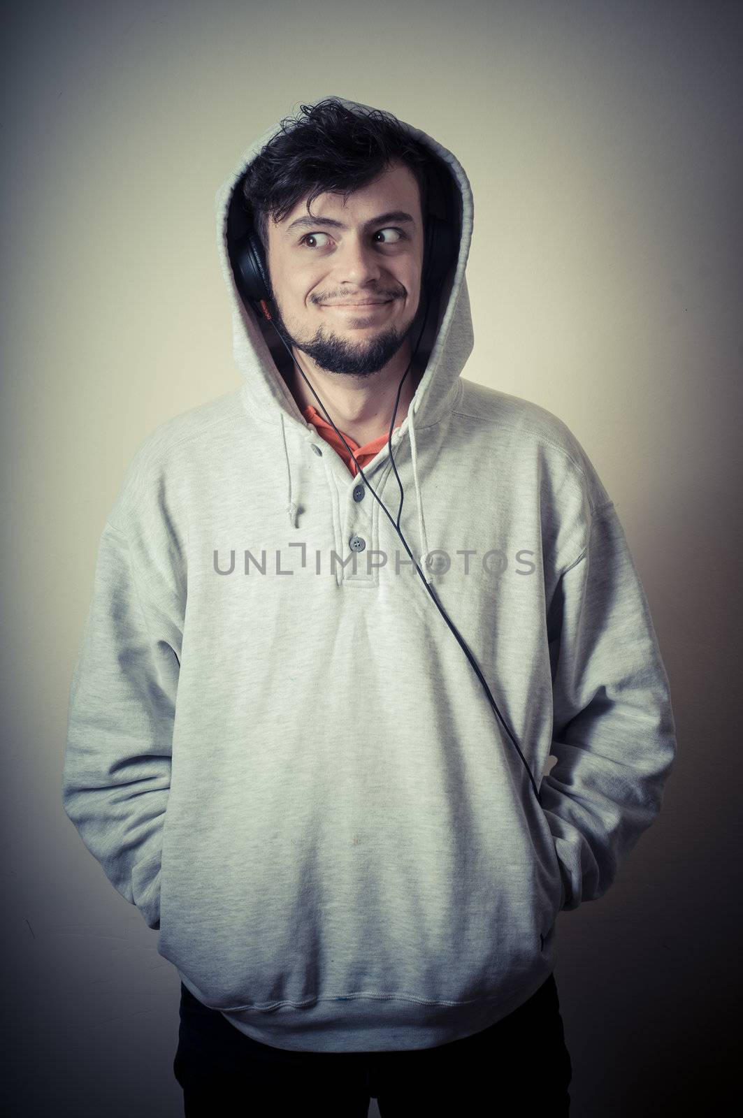 boy with sweatshirt and headphones on gray background 