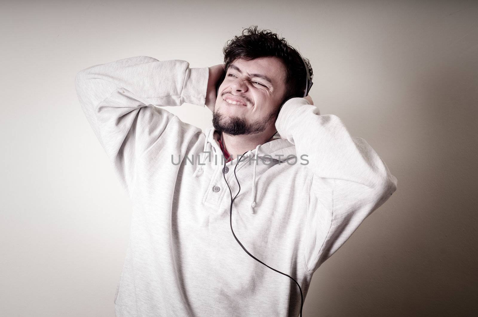 boy with sweatshirt and headphones on gray background 