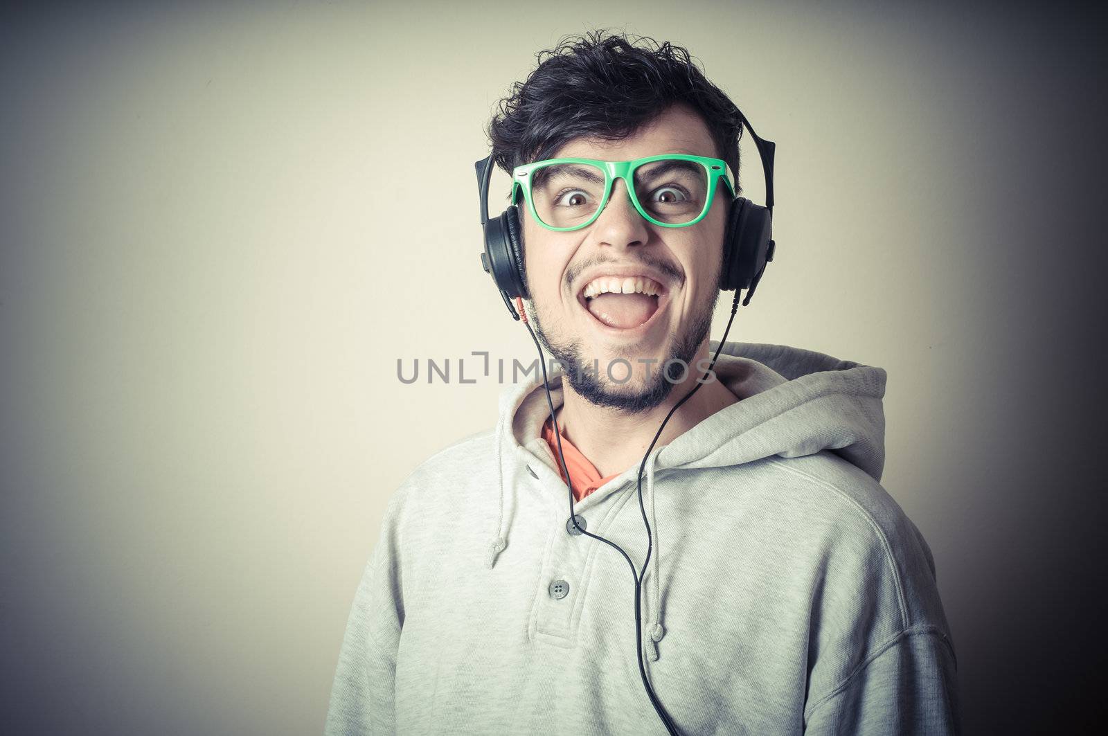 boy with sweatshirt and headphones on gray background 