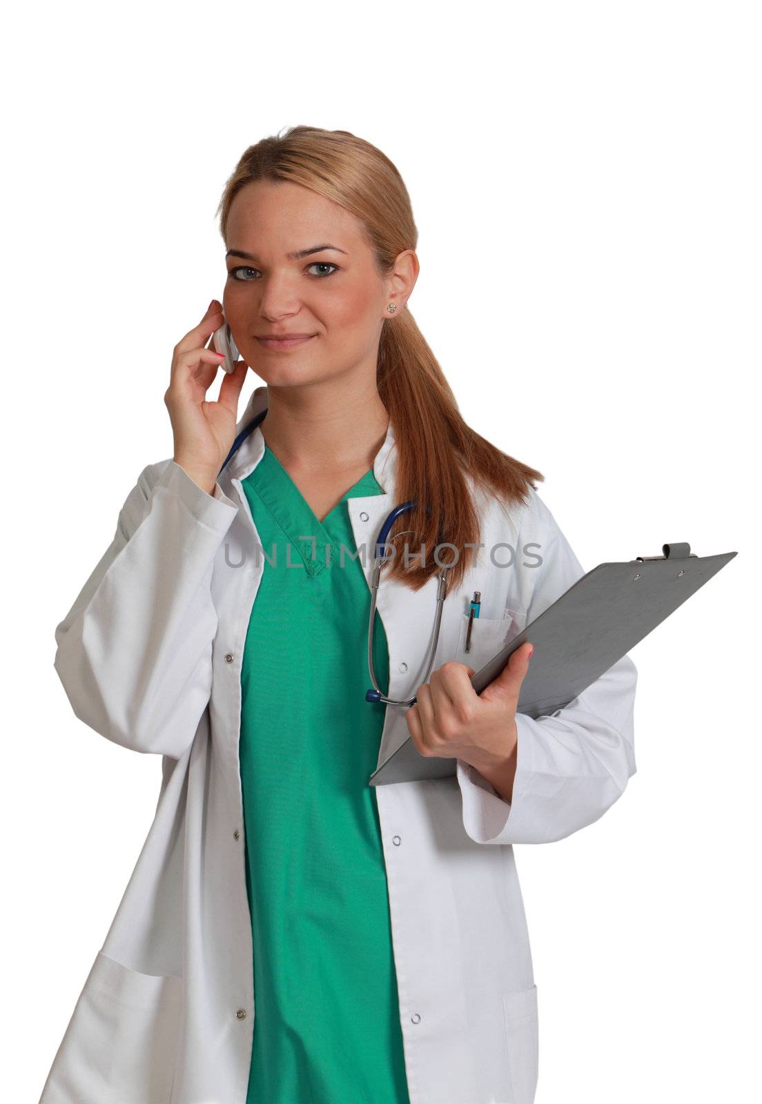 Portrait of a young blonde femeale nurse with clipboard using a mobile phone,isolated against a white background.