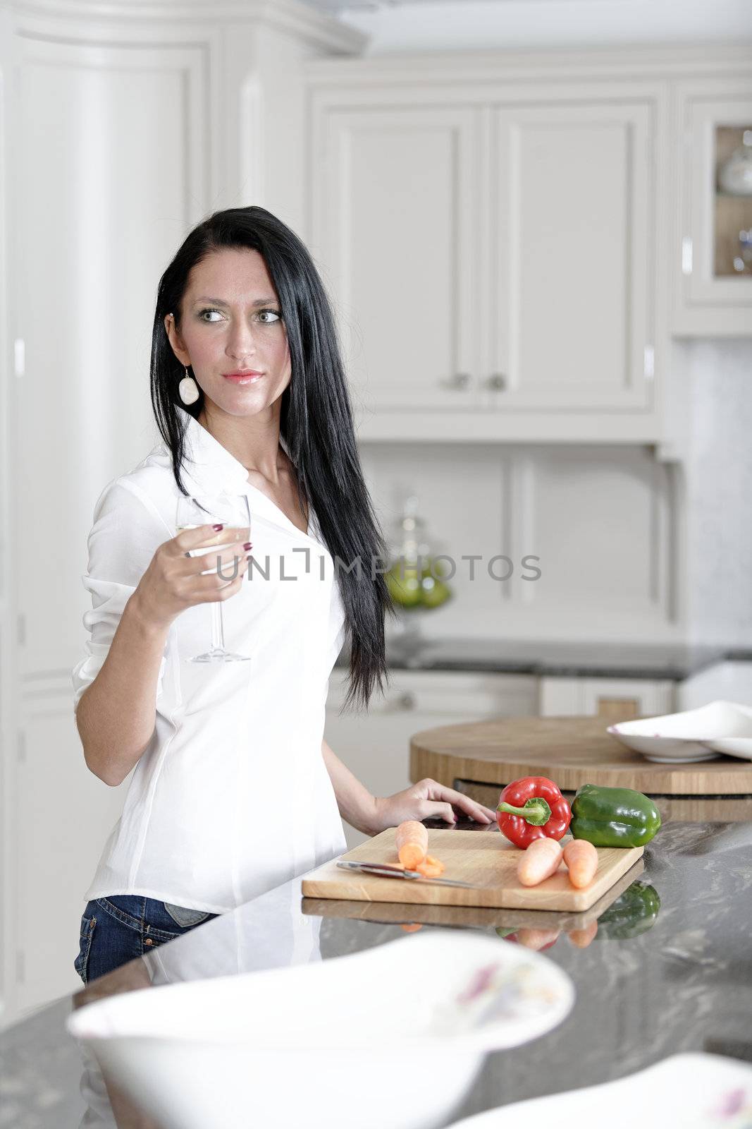 Beautiful young woman preparing the ingredients for a meal in her kitchen.