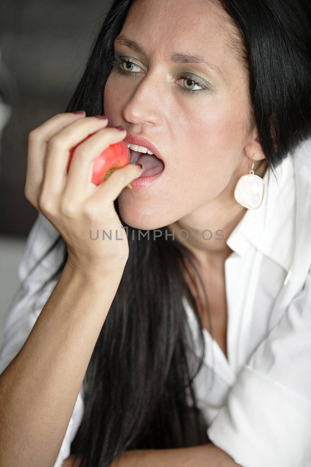 Attractive young woman eating an apple.