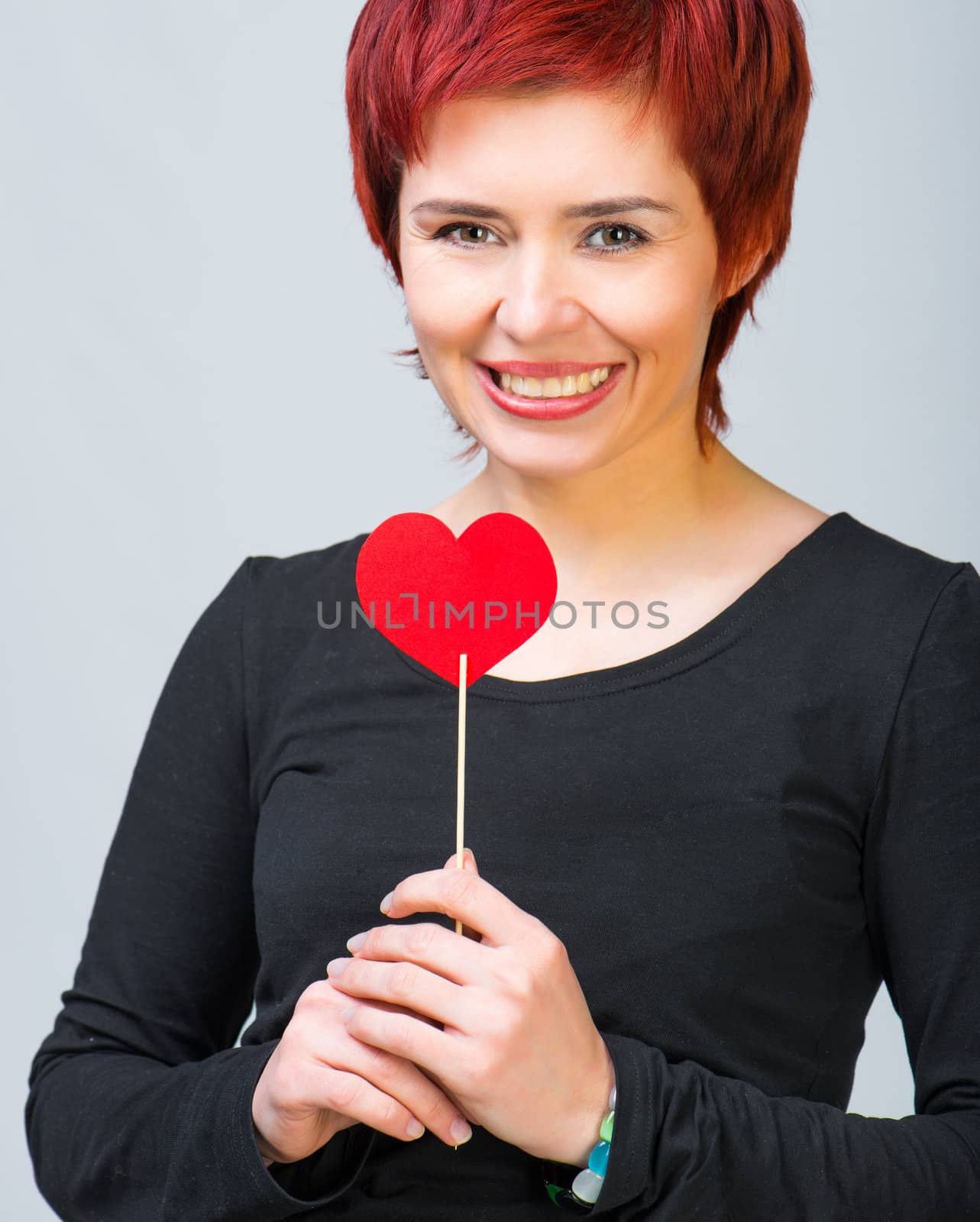 smiling young woman with a red paper heart