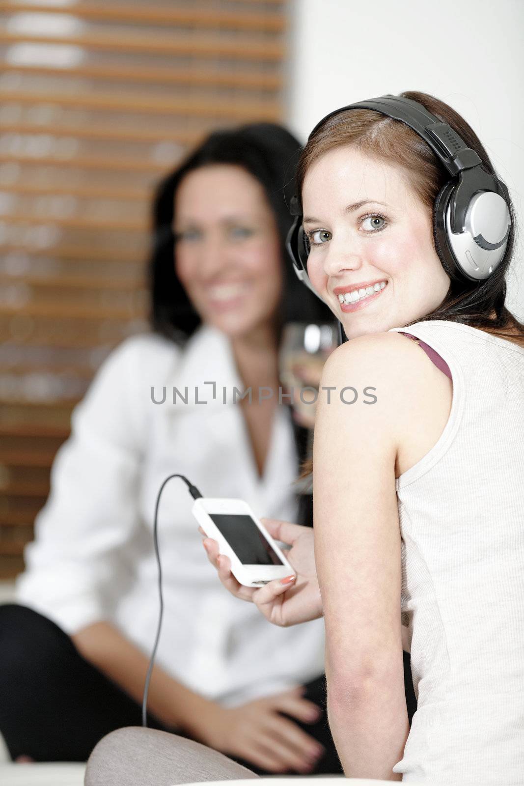 Two friends listening to music by studiofi
