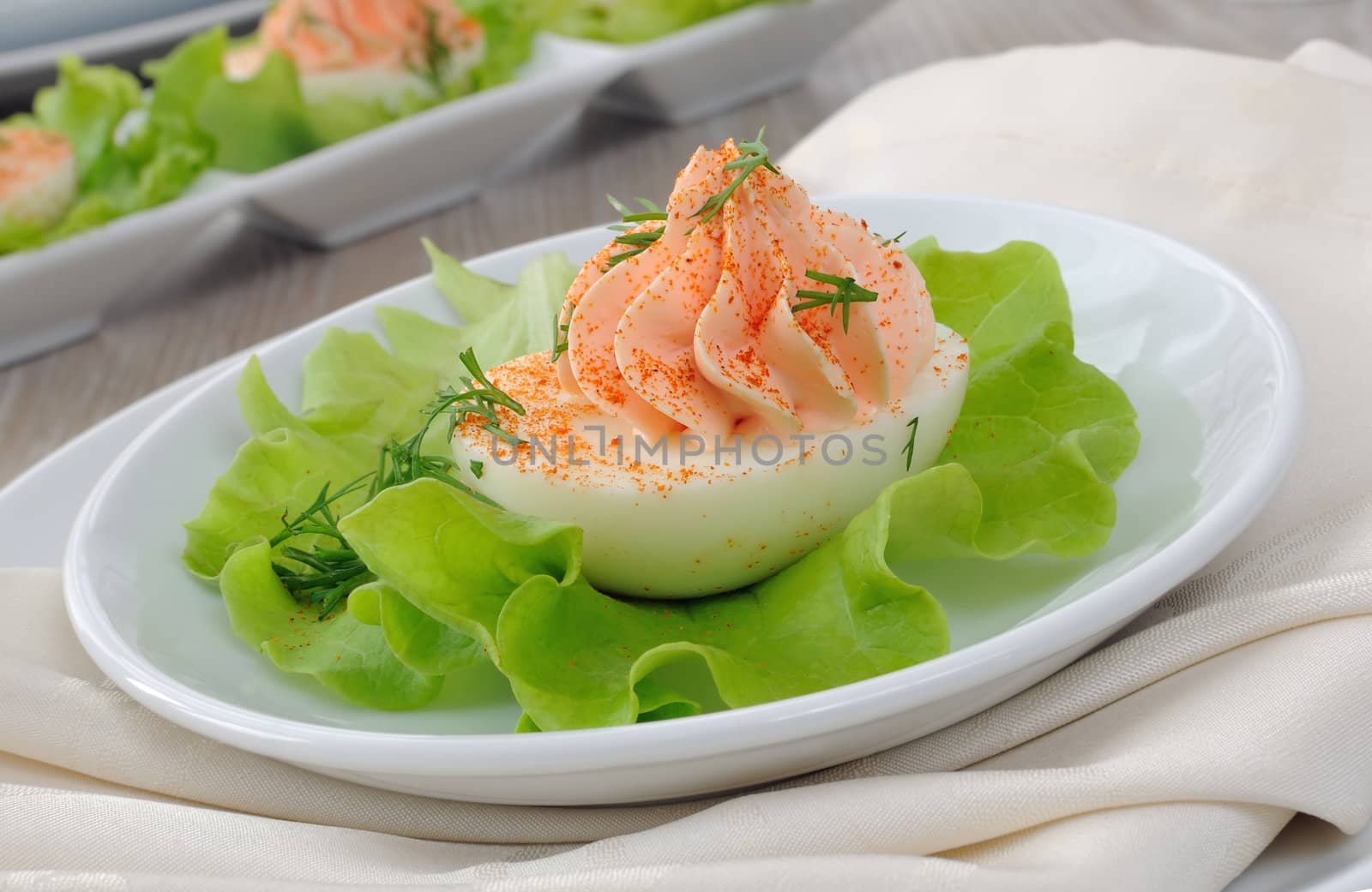 Eggs stuffed with pate salmon with red pepper in lettuce leaves
