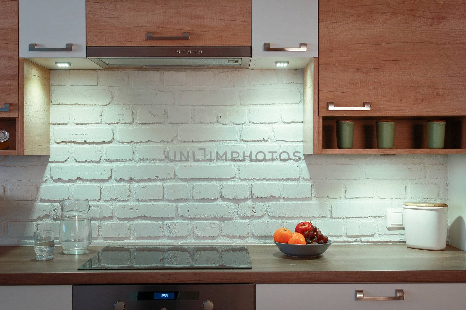 Empty kitchen with a white rustic wall and black cooker