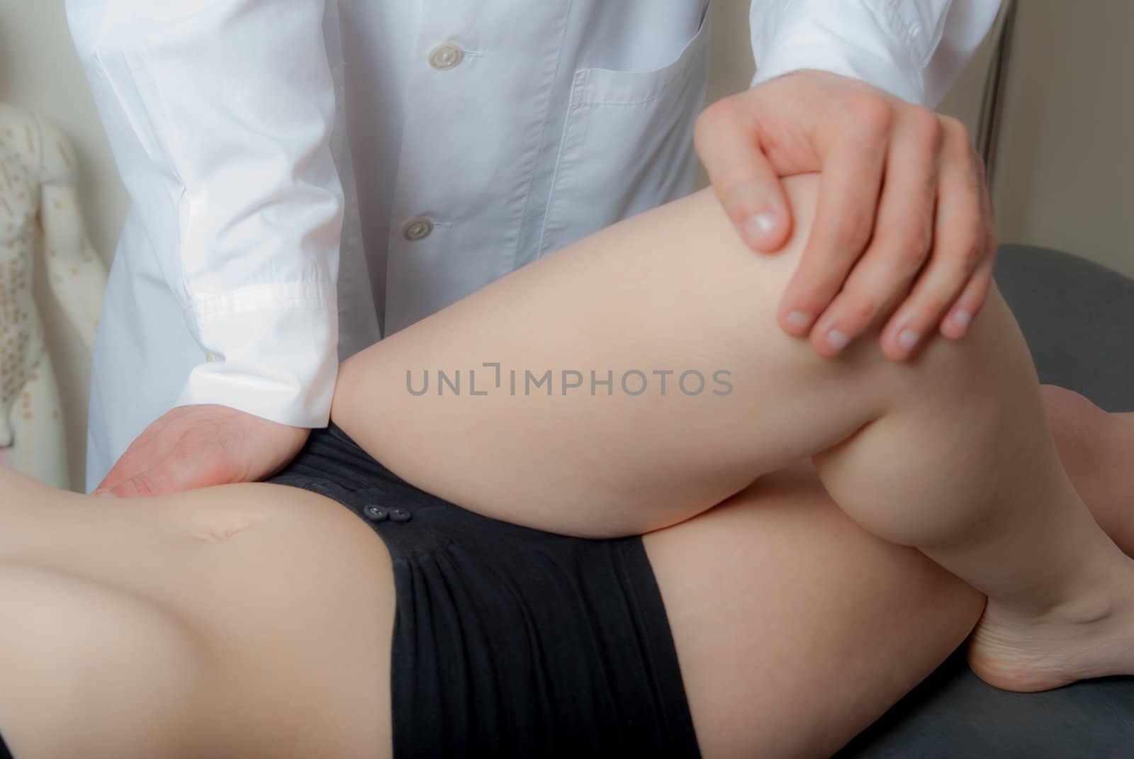 Manual, physio and kinesio therapy techniques performed by a male physiotherapist on a training plastic spine and a female patient