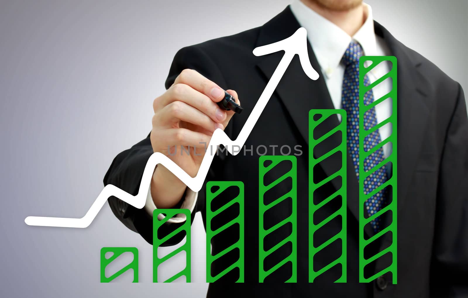 Businessman drawing a rising arrow over growing green bar graph