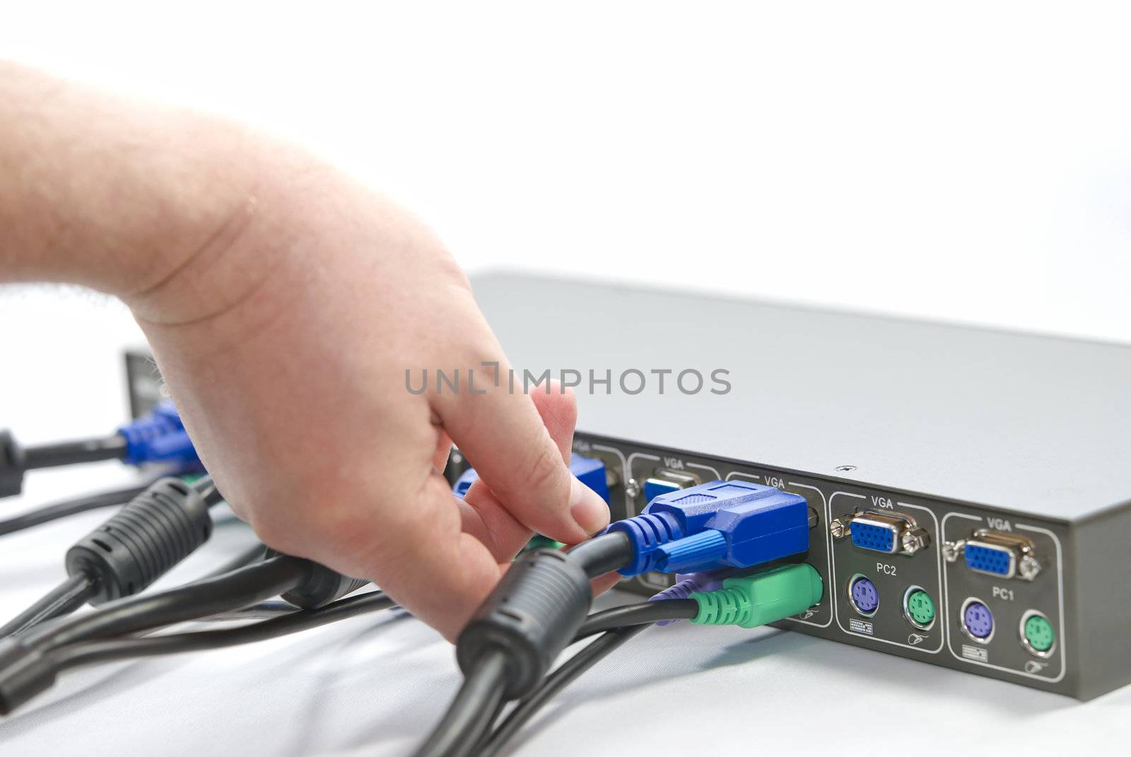 KVM (keyboard, video and mouse) switch and a human hand screwing VGA (Video Graphics Array) connector on white background