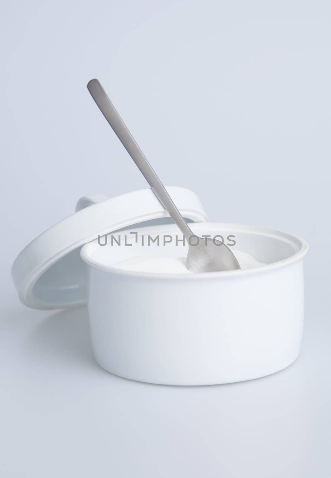 White sugar container with silver spoon